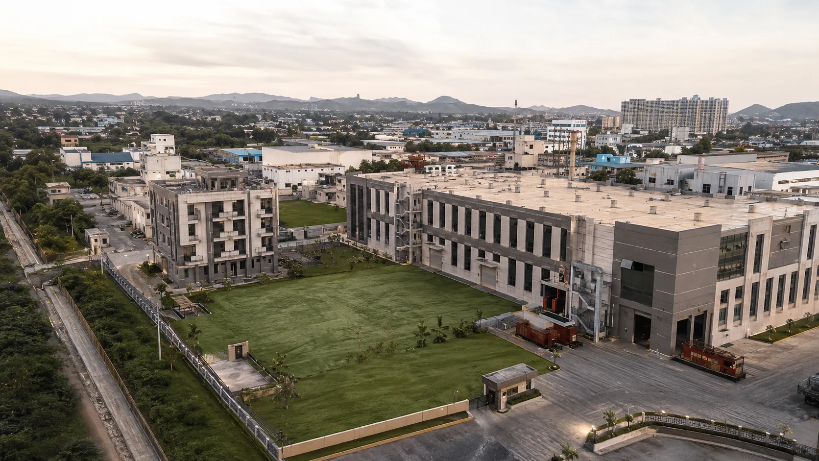 Second aerial angle of the Neemrana manufacturing campus showing the production line, warehouse and dispatch-side buildings.